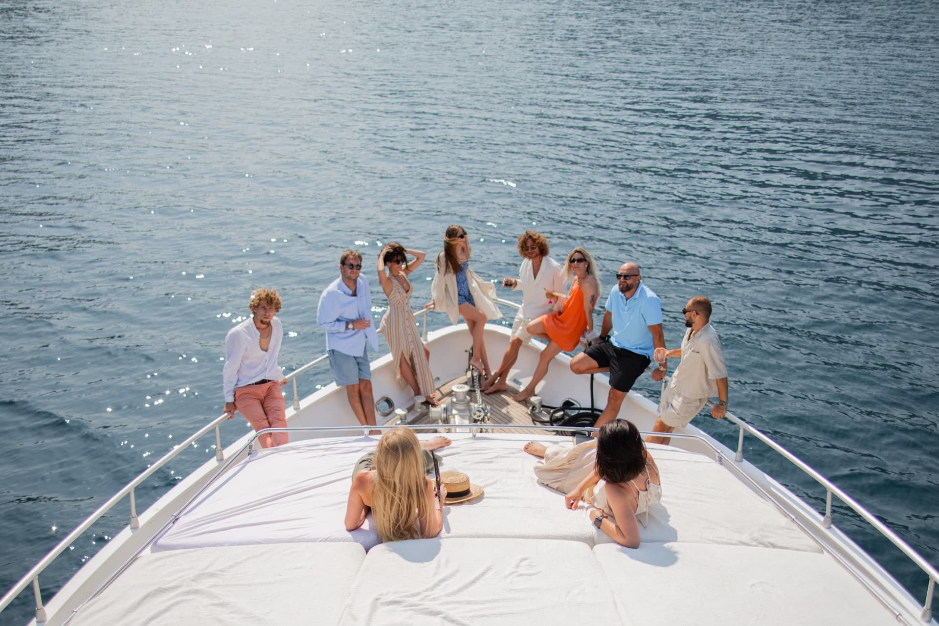Guests along the bow rail of Marea with the mountains of the bay behind
